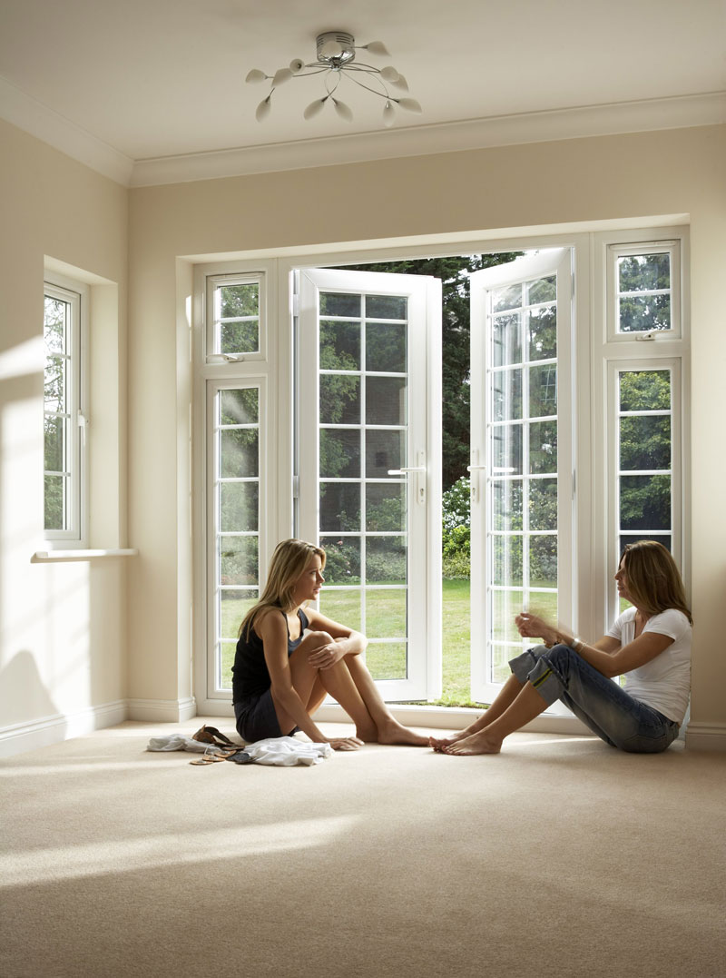 two women sitting near upvc french door